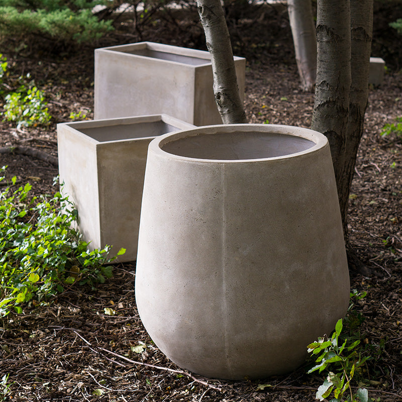 Two large white Dolma planters on a wood deck.