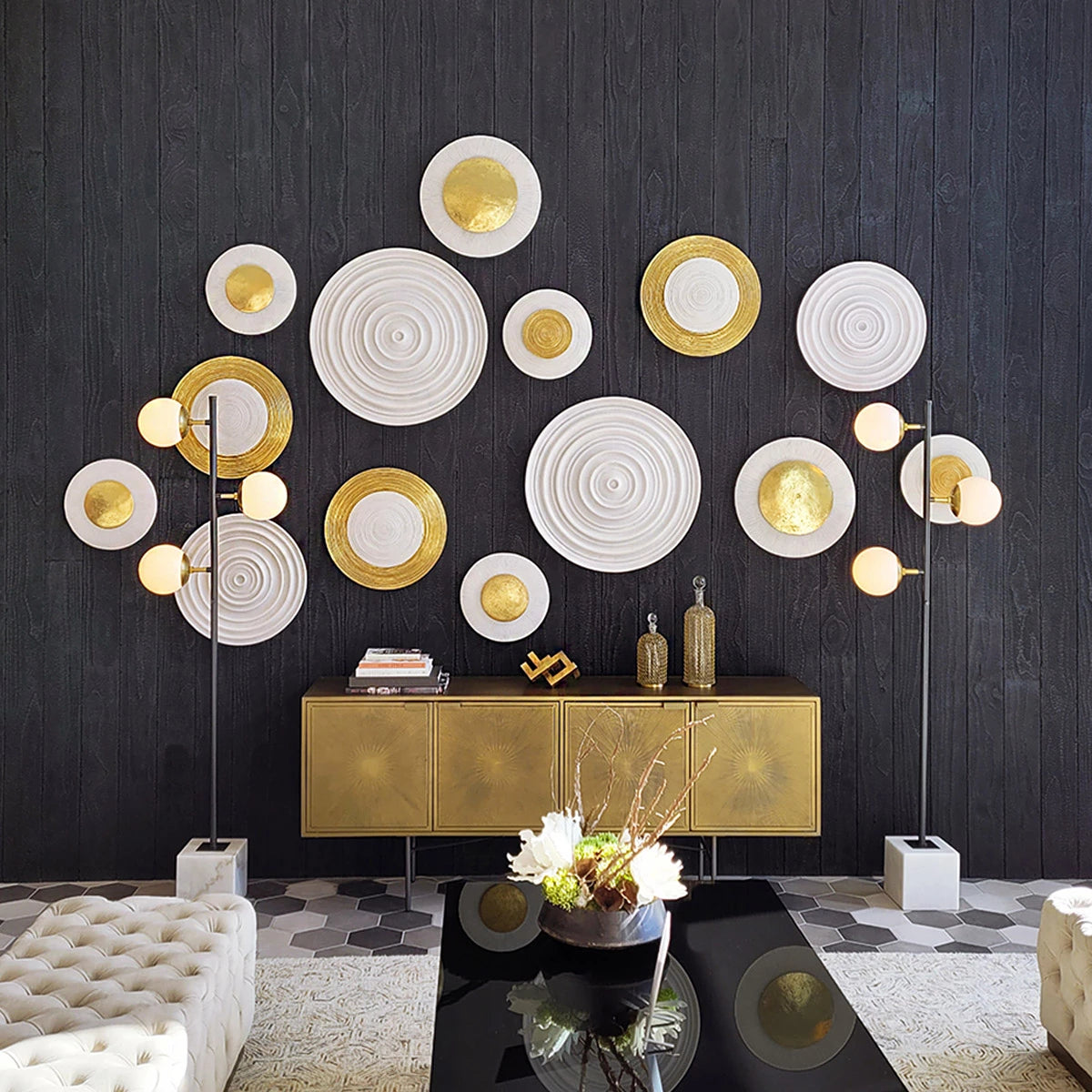 A variety of round gold and white wall art pieces on a black wall in a lobby setting.