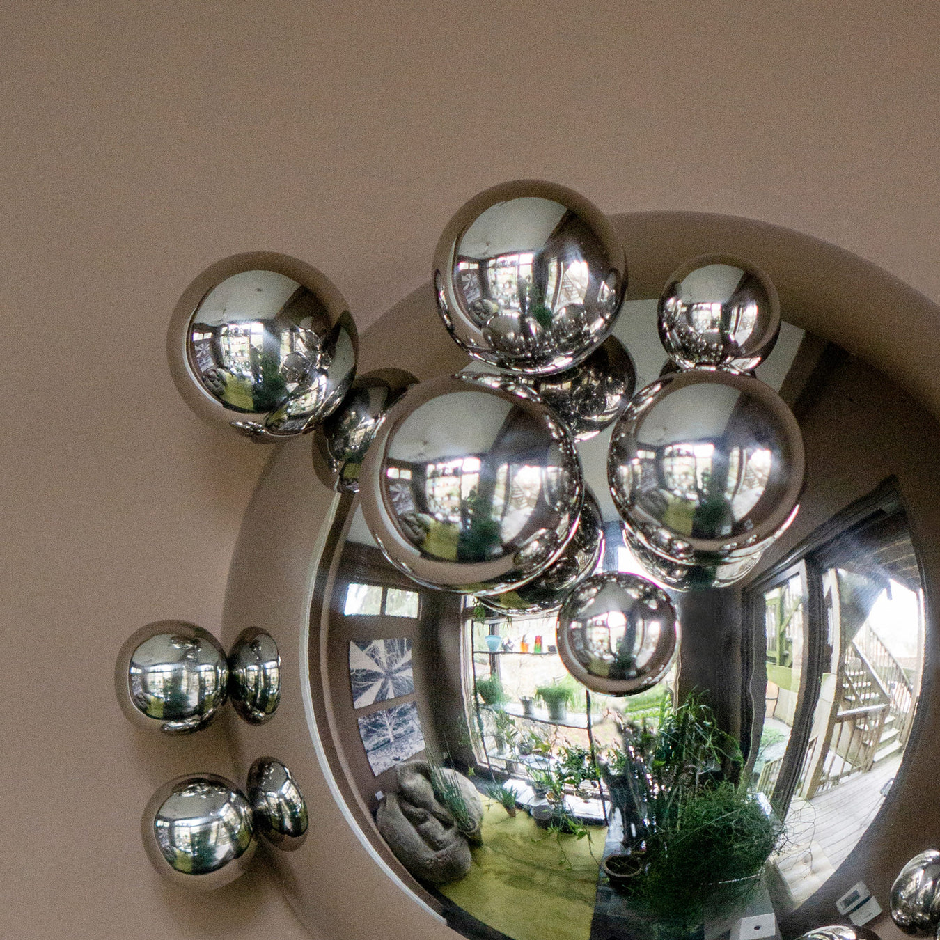 Close up of silver wall sculpture with orbs on it.