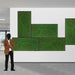 Person standing in a modern office setting with green abstract wall art.