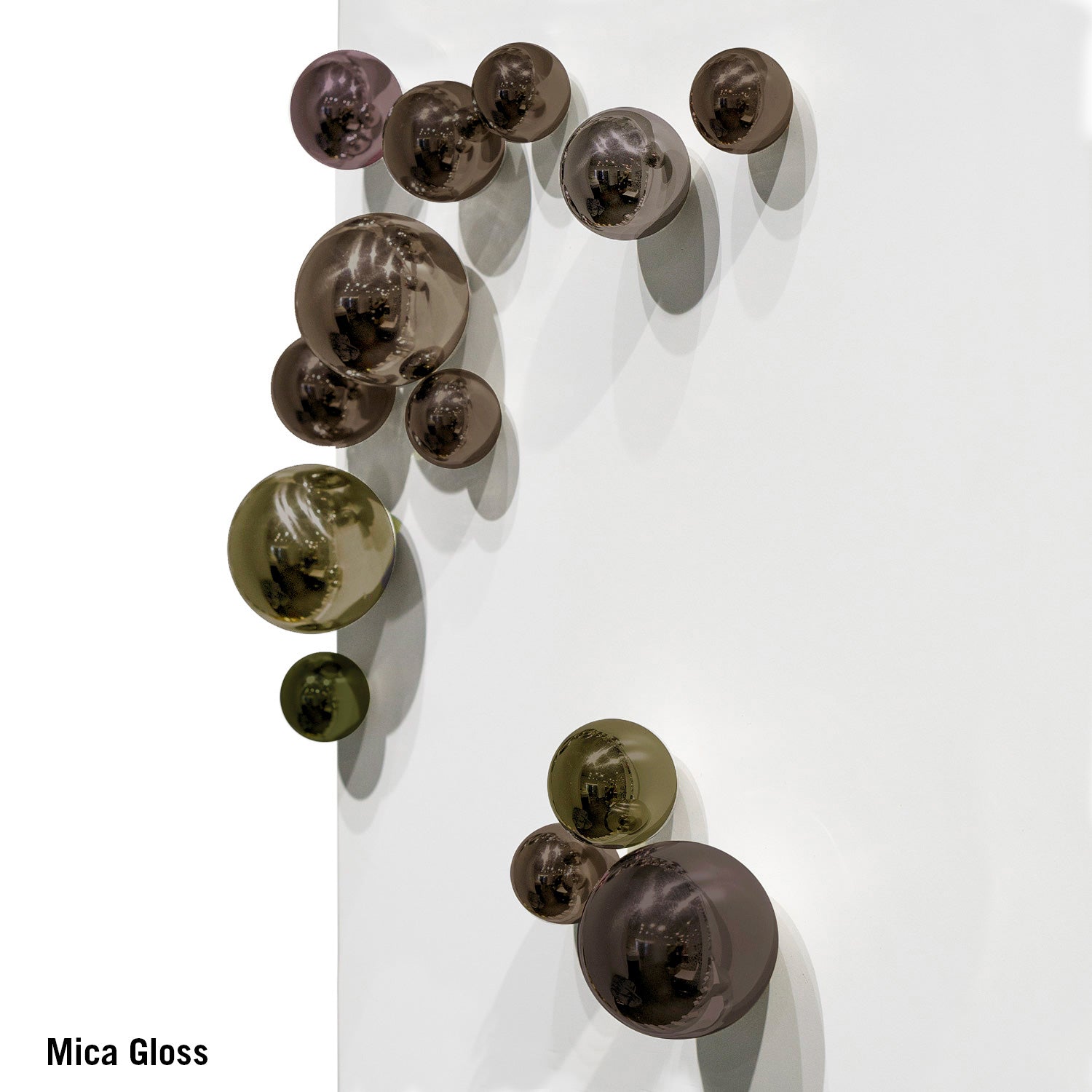 Decorative wall art with spherical, metallic elements on a white background