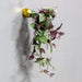 Green and purple vine coming out of a gold Barnacle Wall Play sculpture, mounted on wall. 